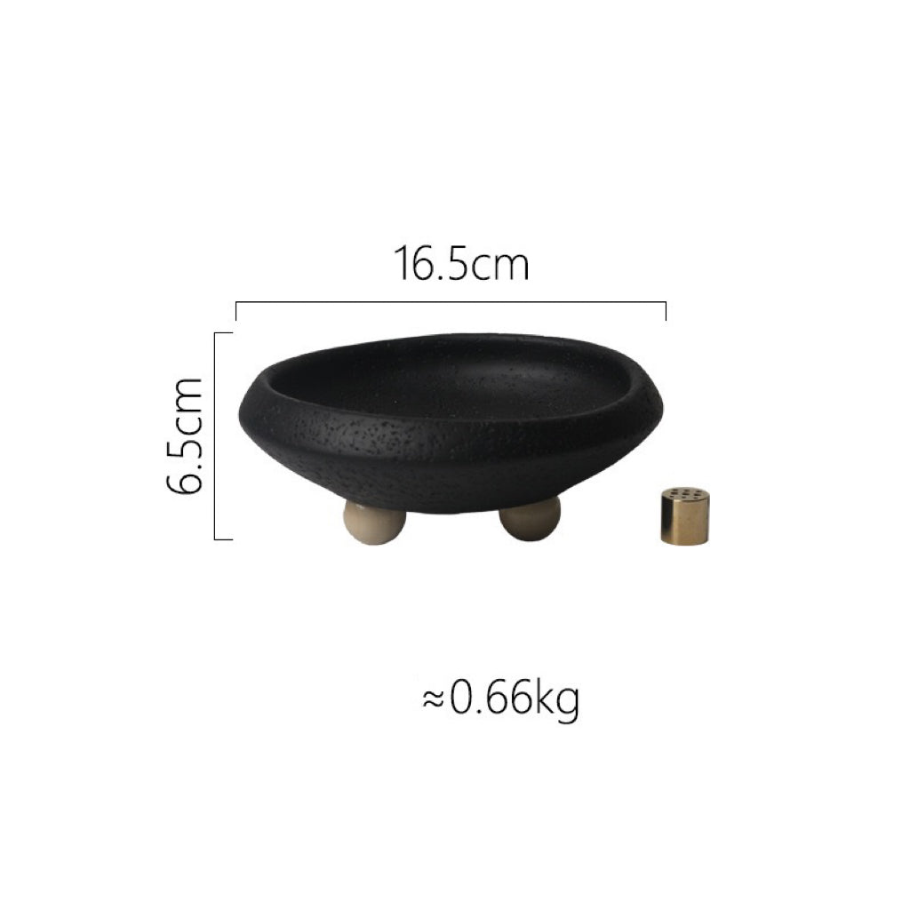 A black decorative bowl with a textured finish, measuring 16.5cm in diameter and 6.5cm in height, resting on three beige feet.