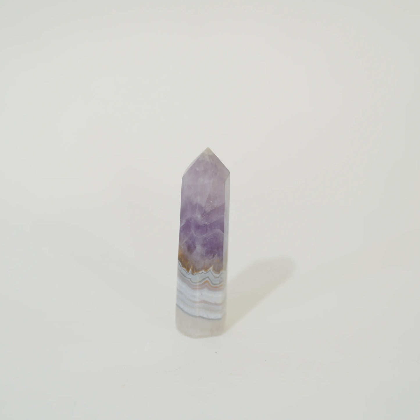 A polished natural Amethyst & Mexican Lace Agate Tower featuring lavender purple, white, and light brown agate banding, standing upright on a plain white background.