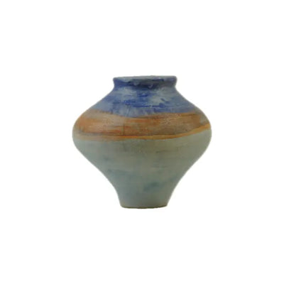 A small, elegantly shaped pottery vase with a blue top and warm orange-brown band, showcasing a smooth, muted green body.