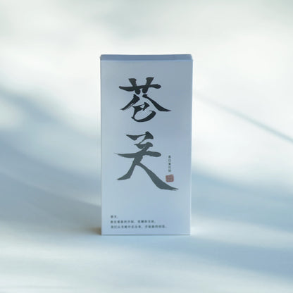 A tall, minimalist white product box standing upright on a soft white surface, featuring large black Chinese calligraphy characters on the front and a small red seal accent.
