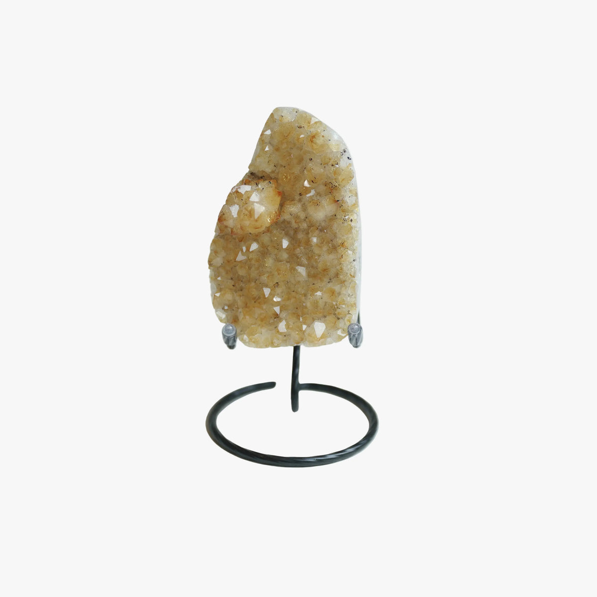 A natural crystal geode specimen with a golden-yellow and white crystalline structure, mounted on a black metal display stand against a plain white background.