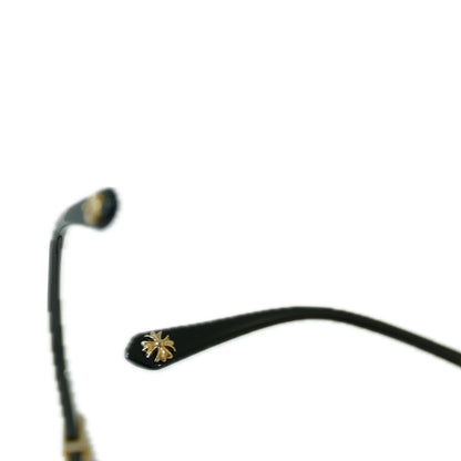 Close-up of a pair of glasses with decorative elements on a white background.