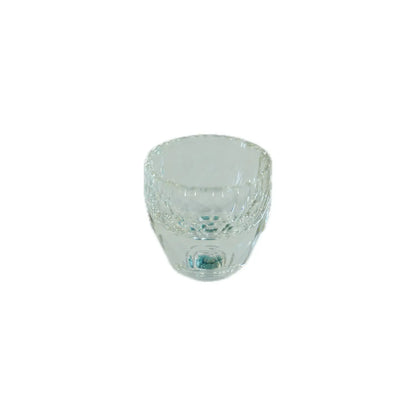 Clear glass cup with decorative elements on a white background
