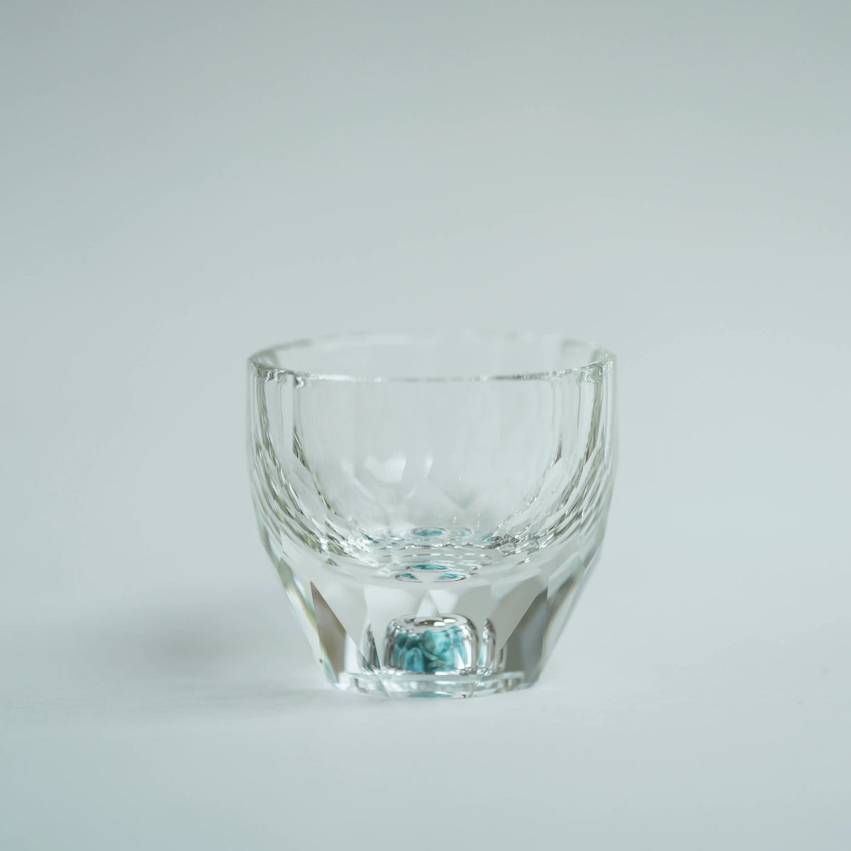 Crystal Turquoise Faceted Cup 65ml on grey background