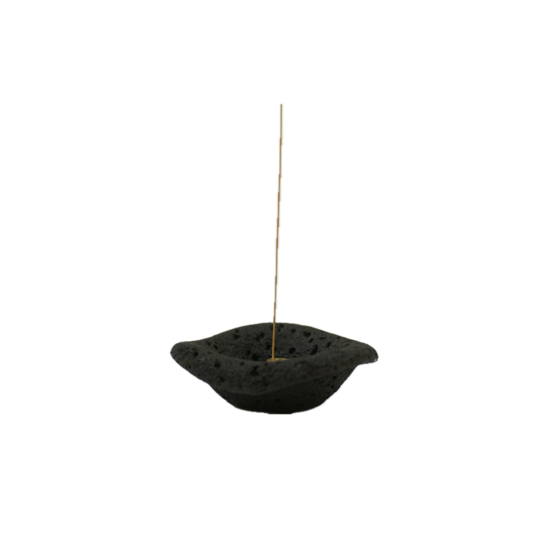 A black, cement incense holder with a dish shape on a white background.