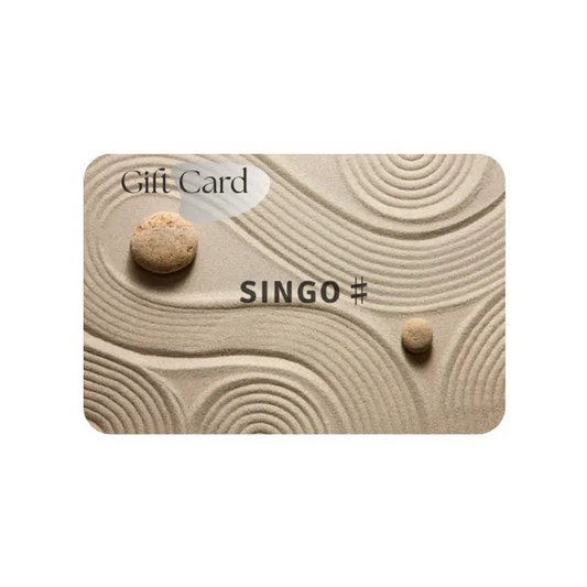 Gift card design featuring a textured sandy background with two stones and the word "SINGO" prominently displayed.