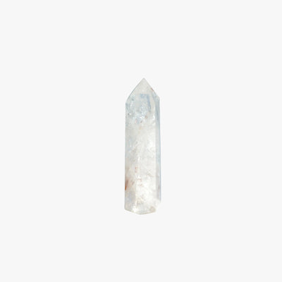 A natural pointed crystal tower, likely golden quartz, featuring a mix of translucent white, light blue, and subtle reddish-brown inclusions, centered on a solid white background.