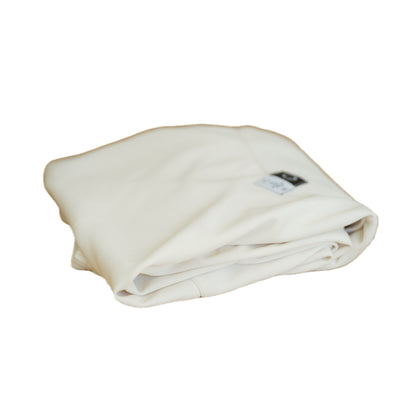 Neatly folded white fabric with a small tag visible, resting on a white background.