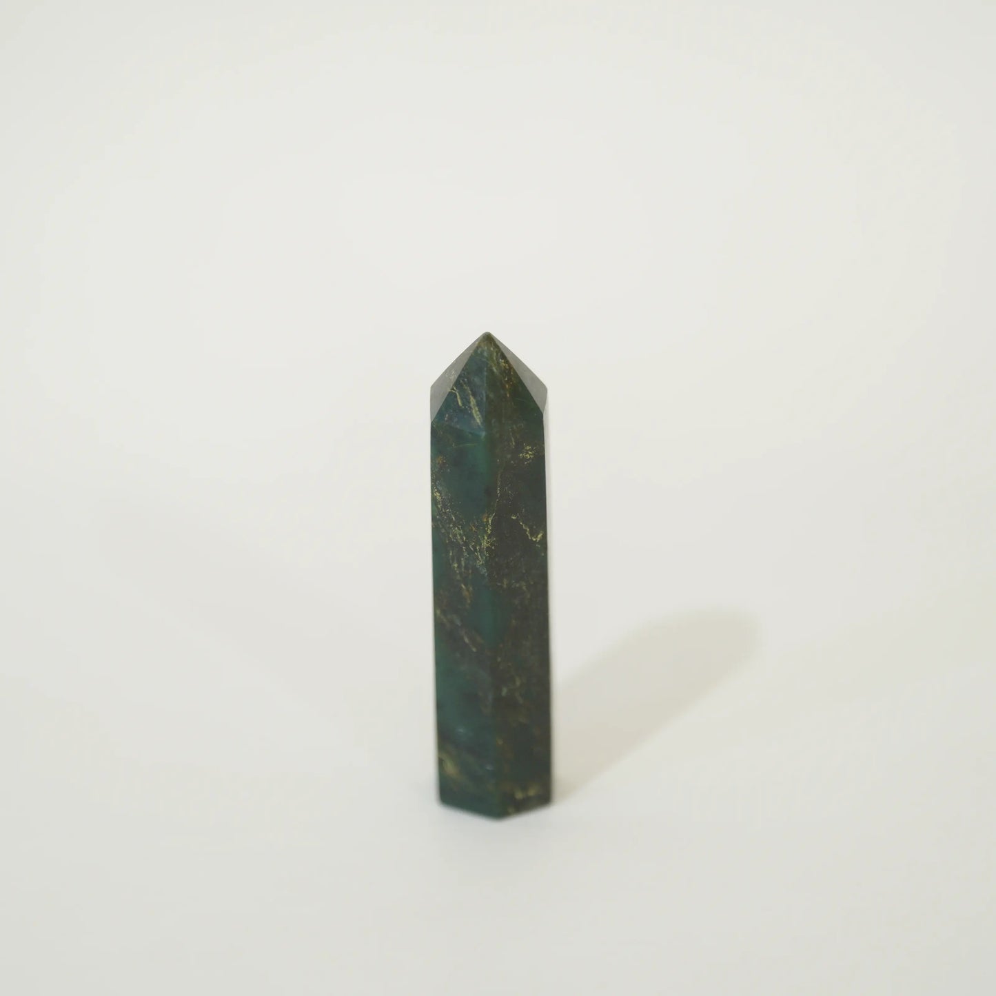 A polished emerald point tower with natural gold veining, standing upright on a clean white background.