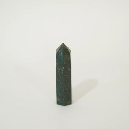 A polished emerald point tower with natural gold veining, standing upright on a clean white background.