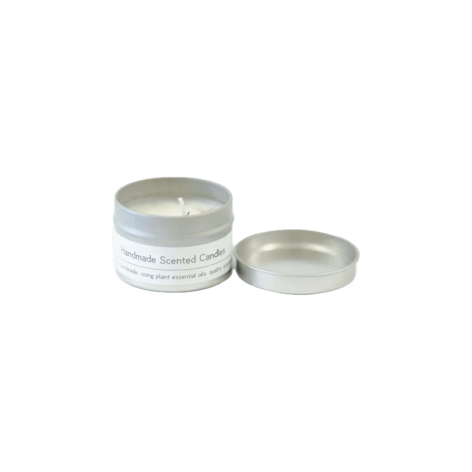 A silver tin with a handmade scented candle inside and its lid beside it on a white background, featuring a label highlighting its quality and essential oil ingredients.
