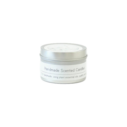 A silver tin candle labeled "Handmade Scented Candles" highlighting its artisanal quality and use of plant essential oils on a white background.