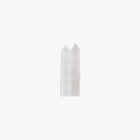 Two small translucent white pointed crystal-like pieces standing upright against a plain white background.