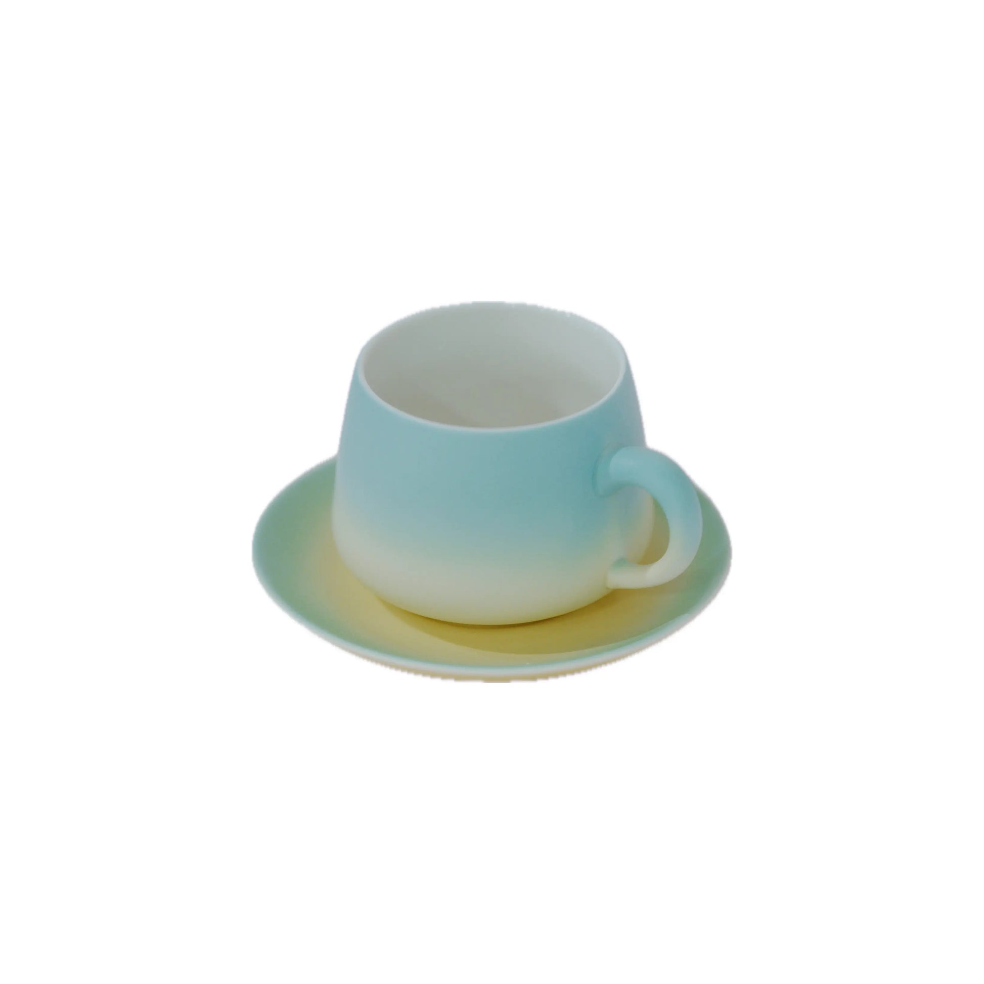 A small ceramic cup and saucer set with a smooth ombre gradient transitioning from light blue at the top to white at the bottom, set against a plain white background.