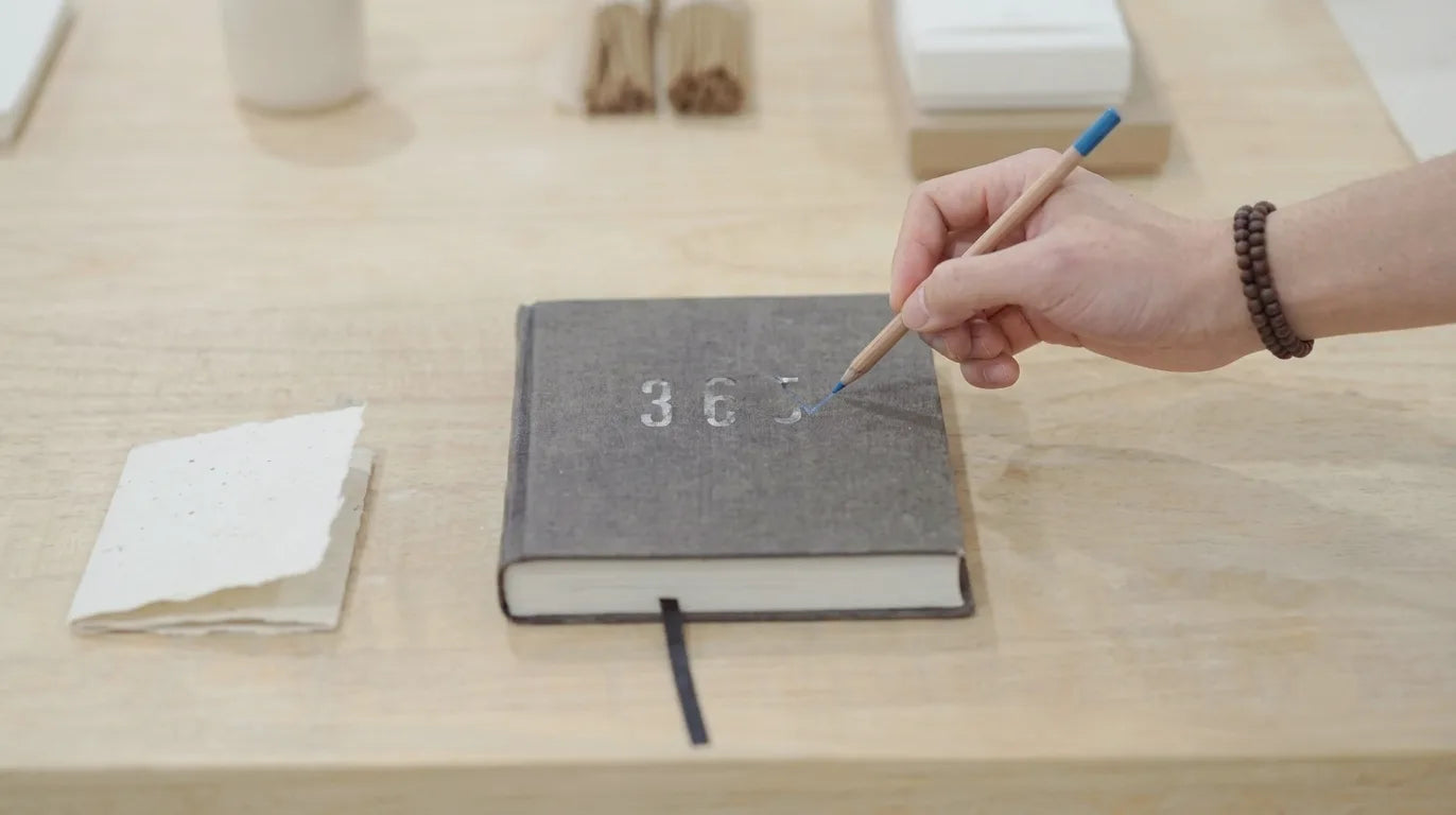 Hand writing on a digital notepad with a pen on a wooden desk.