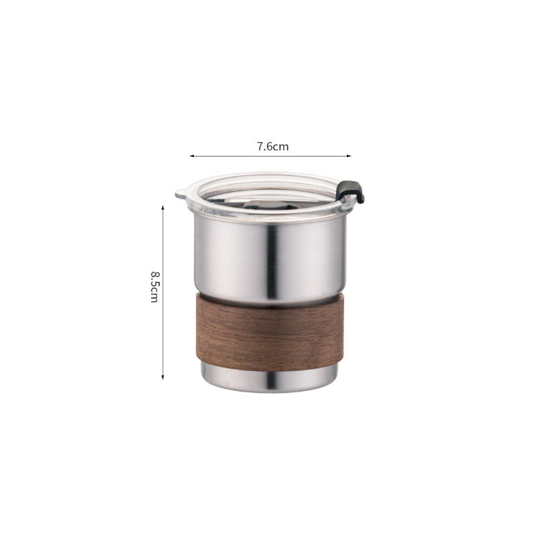 Stainless steel cup with a wooden base, featuring a clear lid, measuring 8.5 cm high and 7.6 cm wide.