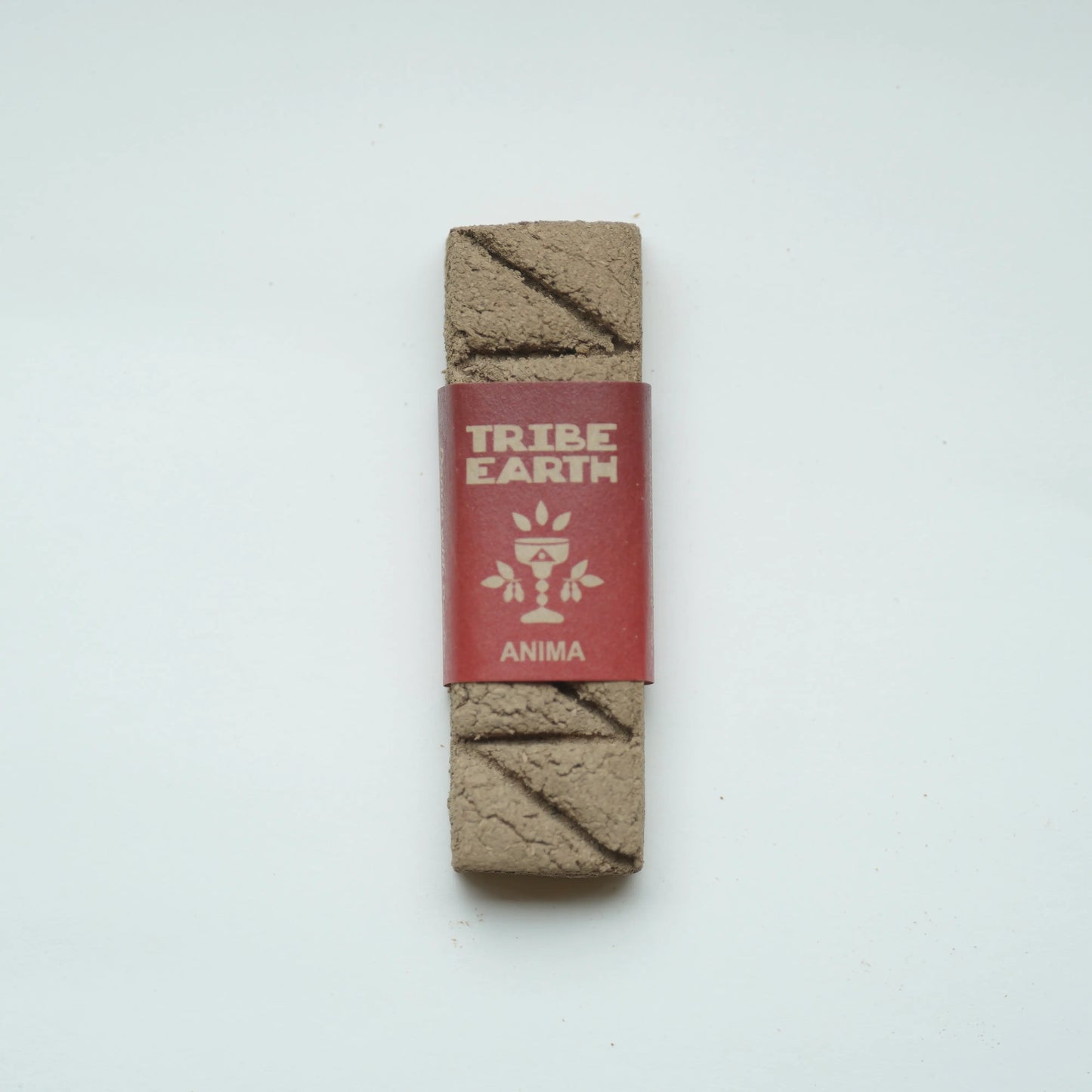 A Tribe Earth Anima incense wrapped in a red paper band, displayed vertically on a clean white background.