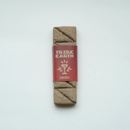 A Tribe Earth Anima incense wrapped in a red paper band, displayed vertically on a clean white background.