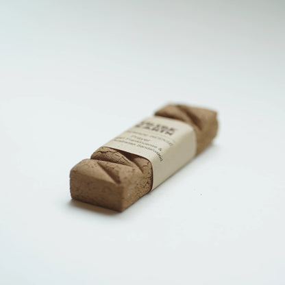 A single Tribe earth prayer incense in a plain kraft paper band, photographed on a clean white background.