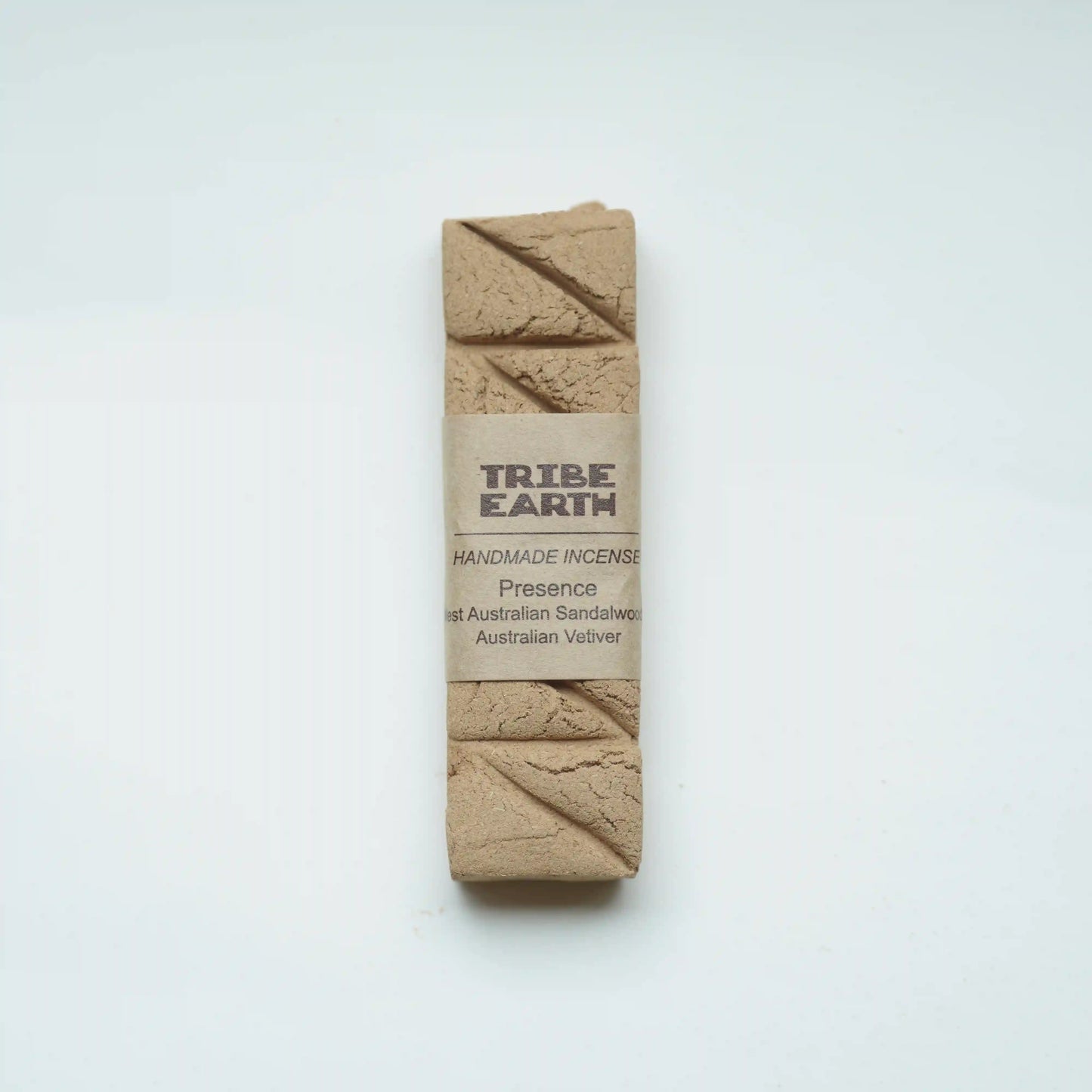 A rectangular bar of Tribe Earth handmade incense wrapped in a kraft paper band, displayed on a clean white background.