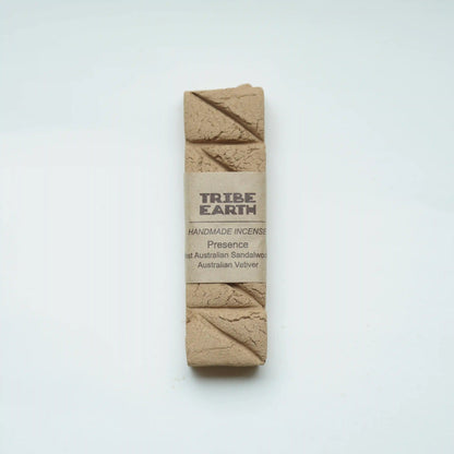 A rectangular bar of Tribe Earth handmade incense wrapped in a kraft paper band, displayed on a clean white background.
