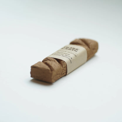 Tribe earth reverence incense wrapped with a beige paper band label, photographed on a clean white background.