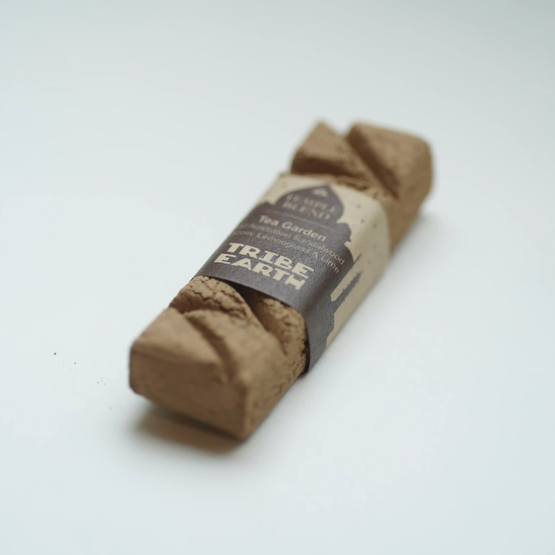 A rolled-up Tribe Earth Tea Garden incense, wrapped in a paper band label, on a clean white background.