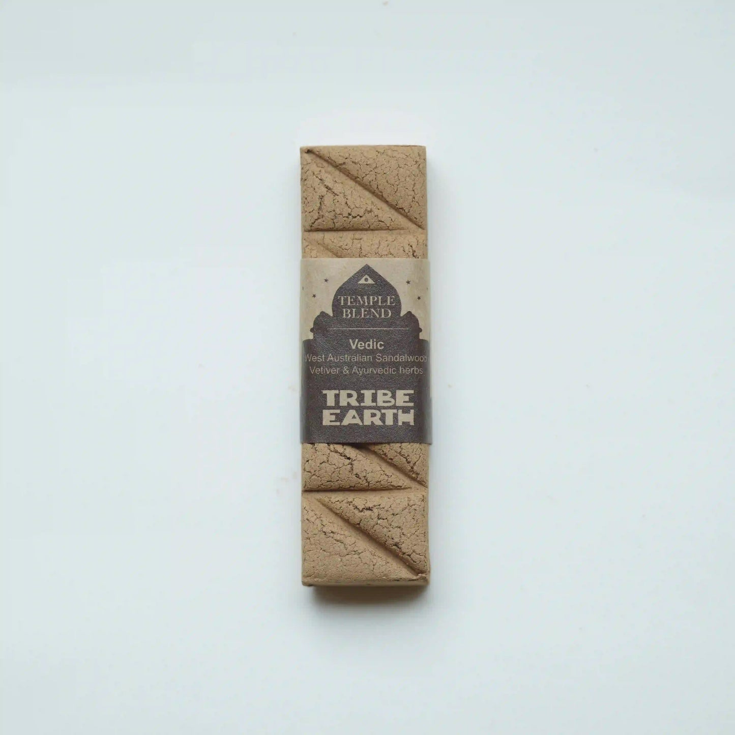 A single packaged Tribe Earth Temple Blend Vedic Sandalwood Ashwagandha and Schisandra Chakra Support Kumbhaka powder bar, wrapped in a brown kraft paper sleeve with a beige and dark brown label, set against a plain white background.