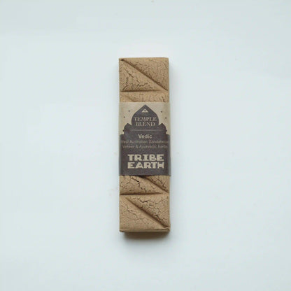 A single packaged Tribe Earth Temple Blend Vedic Sandalwood Ashwagandha and Schisandra Chakra Support Kumbhaka powder bar, wrapped in a brown kraft paper sleeve with a beige and dark brown label, set against a plain white background.
