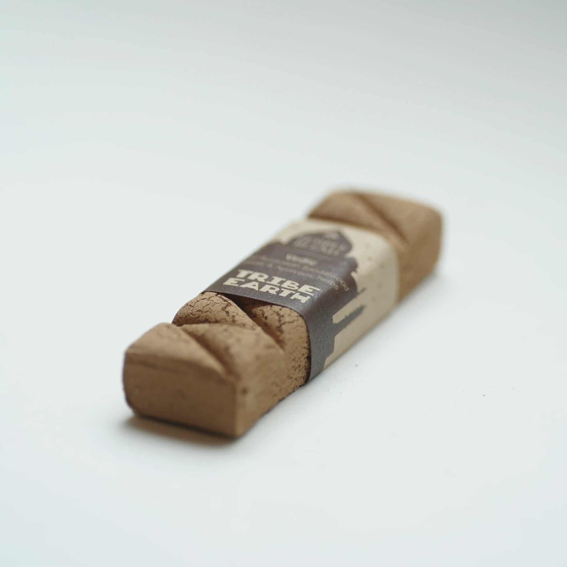 Tribe Earth vedic incense bar wrapped in a brown paper band, photographed on a clean white background.
