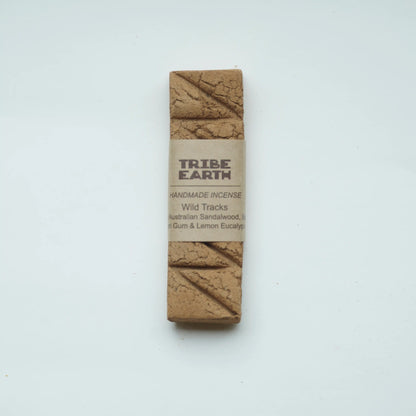 A single rectangular bar of Tribe Earth Handmade Incense wrapped in a beige paper band, displayed vertically on a clean white background.