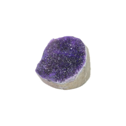 A natural amethyst geode dome with a deep purple crystal interior and a light gray stone base, shown on a plain white background.