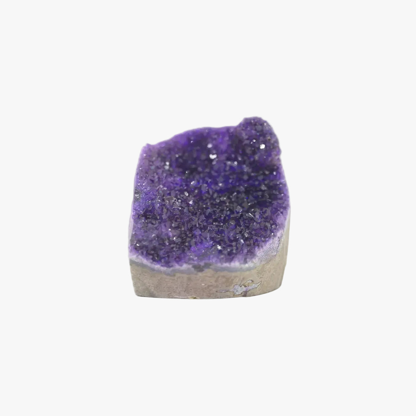 A raw amethyst geode specimen with a deep purple crystalline interior and a light brown to beige rough outer matrix, isolated on a solid white background.