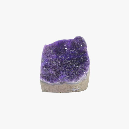 A raw amethyst geode specimen with a deep purple crystalline interior and a light brown to beige rough outer matrix, isolated on a solid white background.