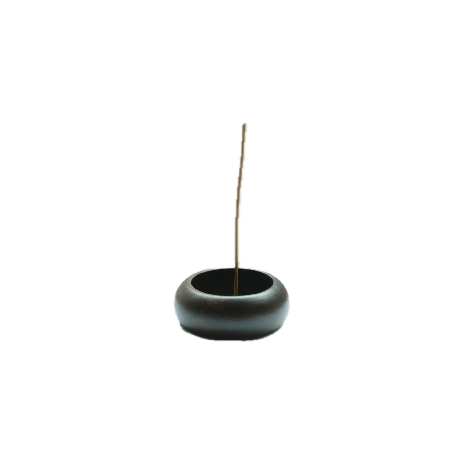 Black wood incense burner with a single incense stick on a white background