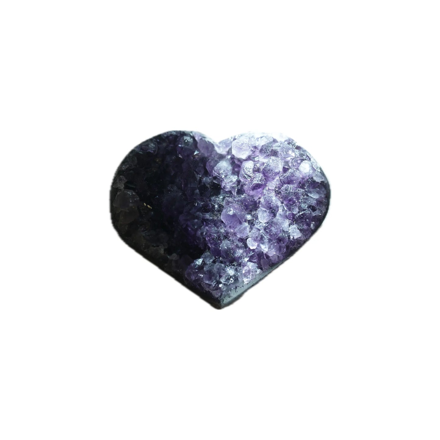 An overhead photograph of a heart-shaped Amethyst geode cluster from Singoau, isolated on a white background. Dramatic lighting creates a high-contrast 'eclipse' effect, with half in shadow and the other half revealing sparkling purple facets, perfect for deep meditation and calm decor.