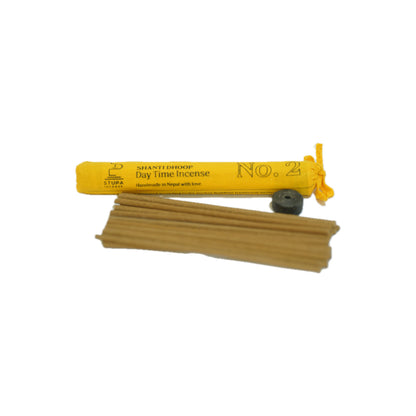 A flat-lay perspective of the complete STUPA 'Day Time' incense kit, including the yellow tube, the full bundle of 19 sticks, and the black minimalist holder, handcrafted in Nepal and presented by Singoau.